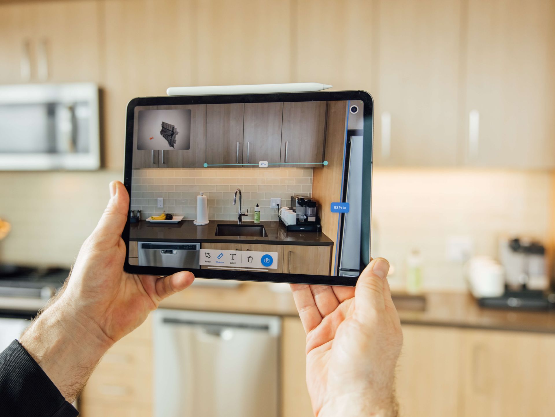 An expert uses Streem's AR-powered video on an iPad to measure a fridge